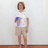 Woman holding a colorful bag against a white wall