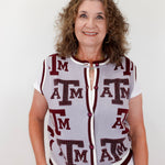 Woman wearing a sleeveless cardigan with 'ATM' pattern on a white background