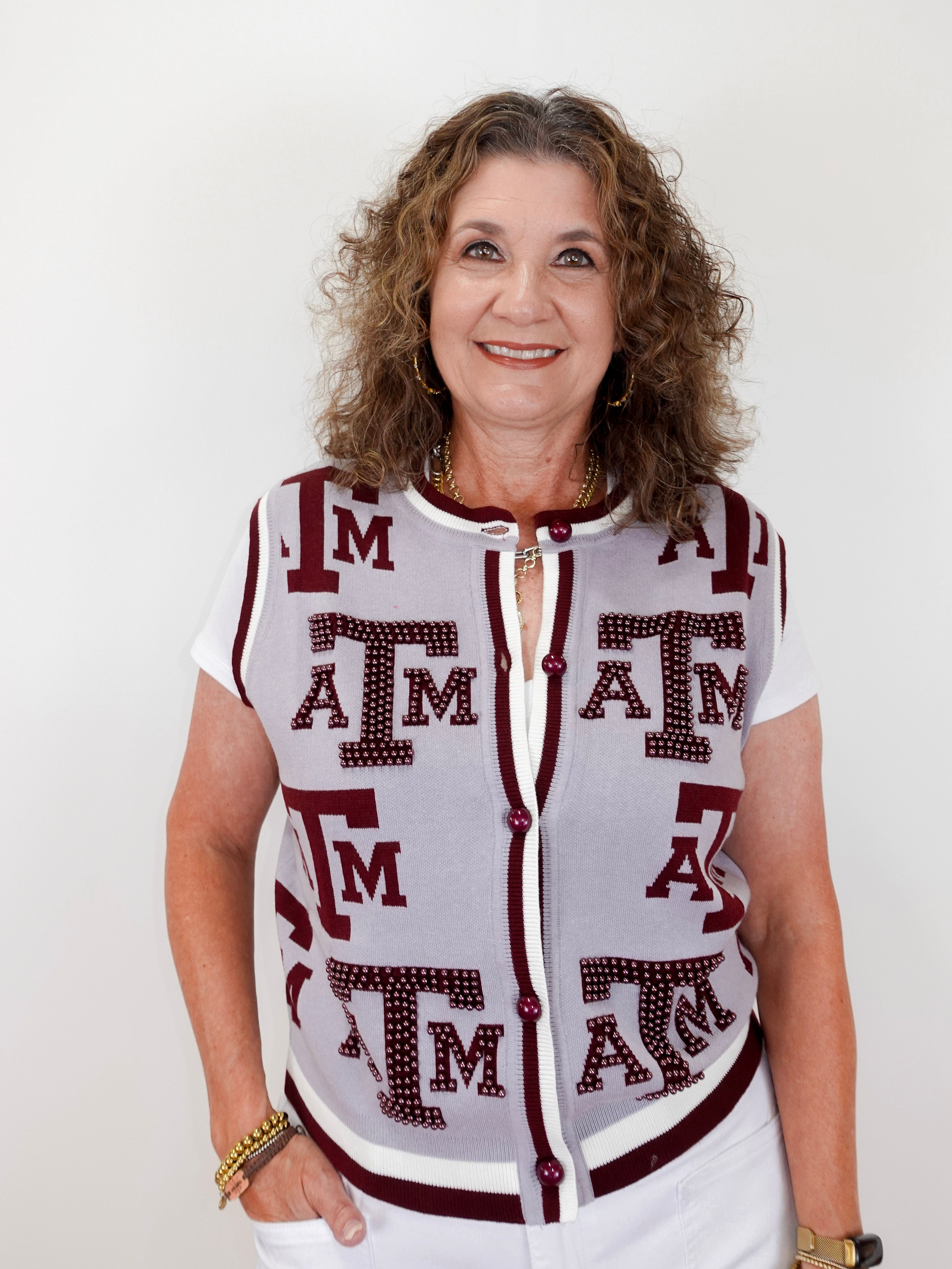 Woman wearing a sleeveless cardigan with 'ATM' pattern on a white background