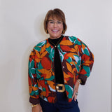 Person wearing a colorful patterned jacket against a plain background