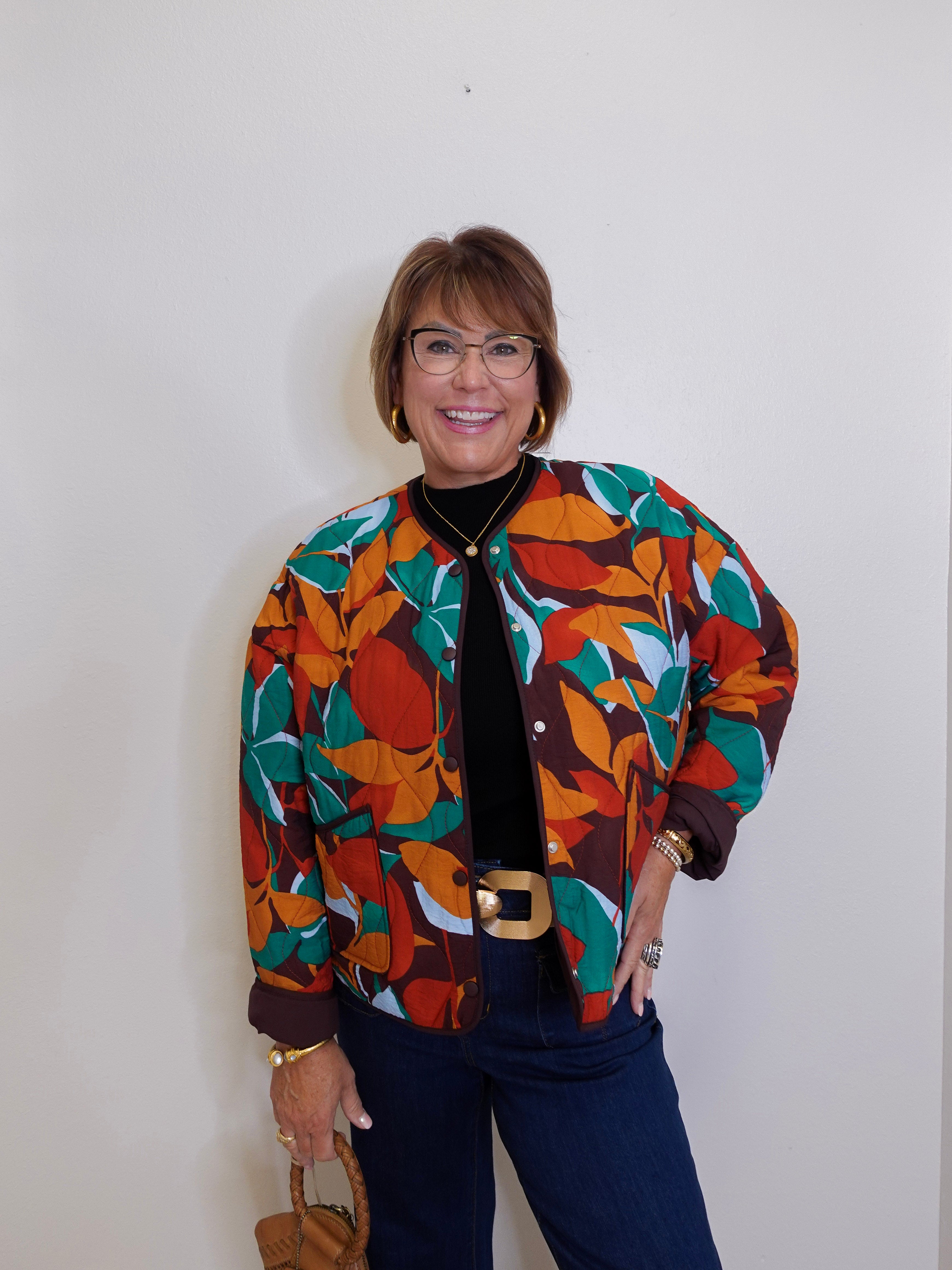 Person wearing a colorful patterned jacket against a plain background