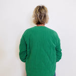 Person wearing a green sweater against a white background