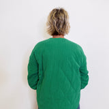 Person wearing a green sweater against a white background
