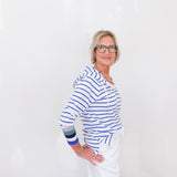 Woman wearing a blue and white striped shirt with colorful sleeves on a white background