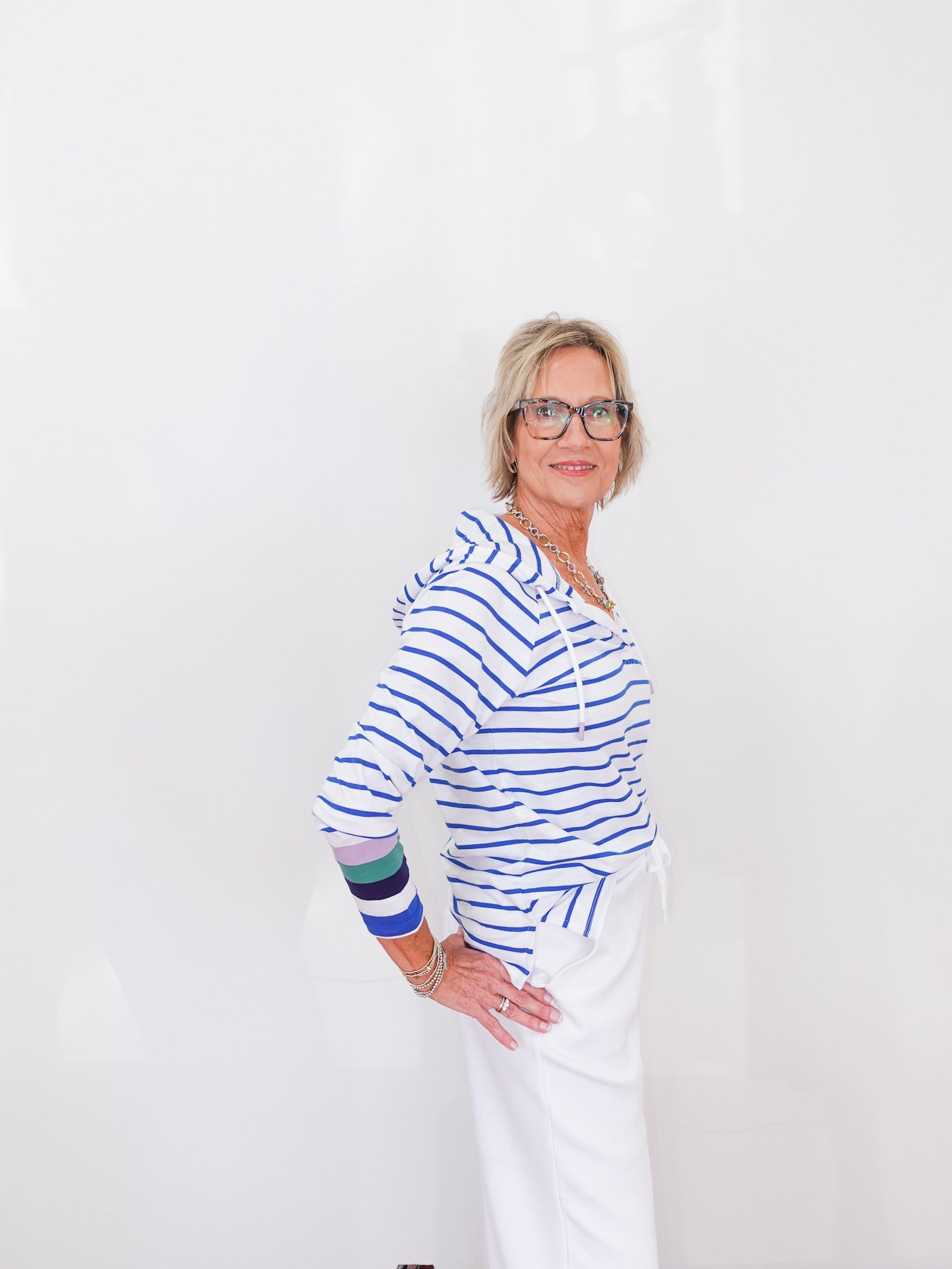 Woman wearing a blue and white striped shirt with colorful sleeves on a white background