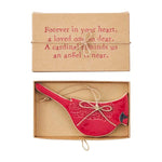 Red cardinal ornament in a cardboard box with a sentimental message.