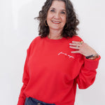 Woman wearing a red sweatshirt with text on a white background