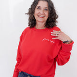 Woman wearing a red sweatshirt with text on a white background
