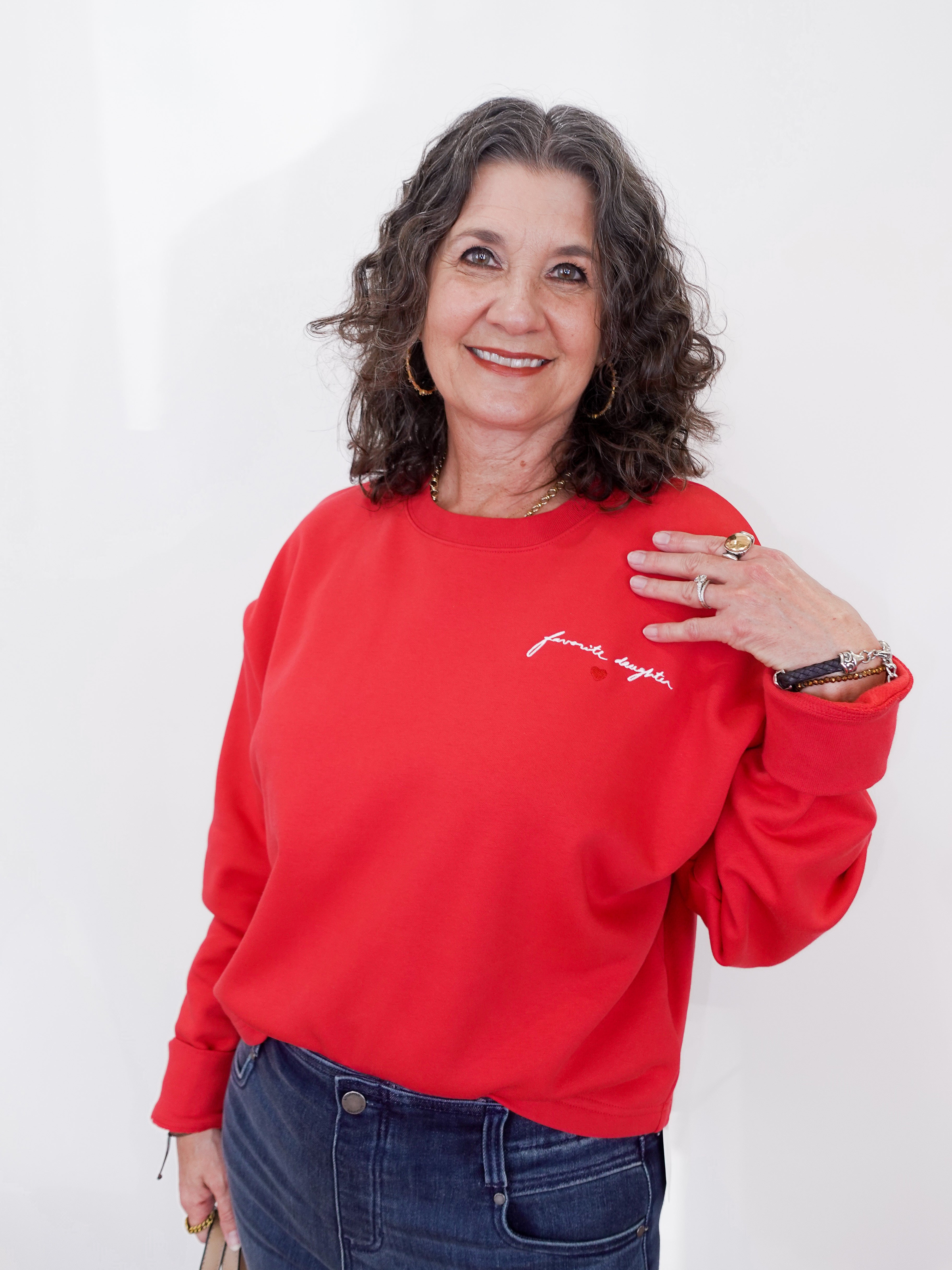 Woman wearing a red sweatshirt with text on a white background
