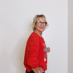 Person wearing a red sweatshirt with a logo against a white background