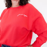 Person wearing a red sweatshirt with text on a white background