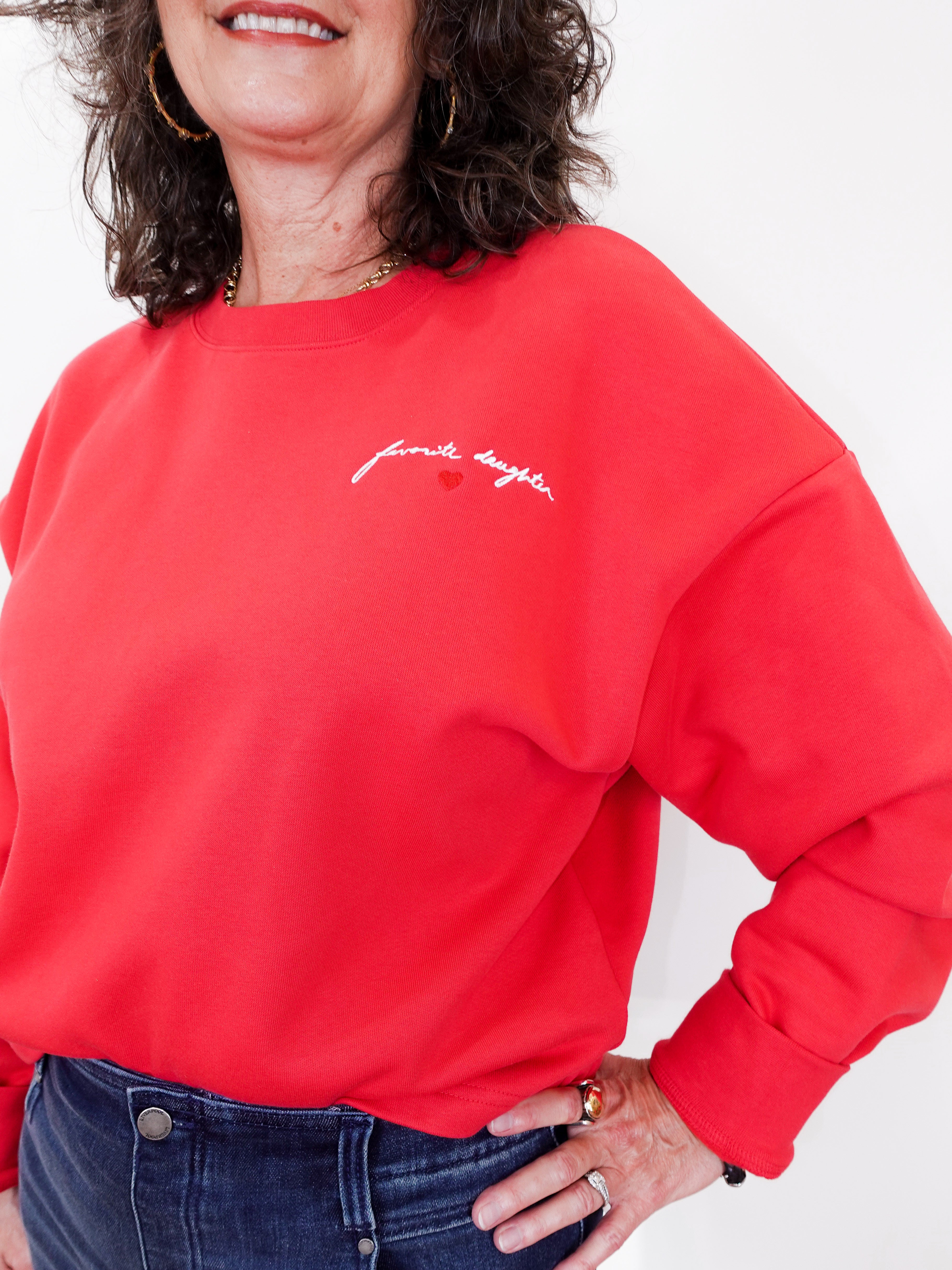 Person wearing a red sweatshirt with text on a white background