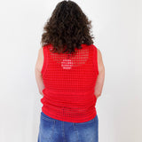 Person wearing a red crochet vest on a white background