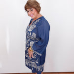 Woman wearing a blue dress with white patterns against a white background