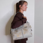 woman wearing the hobo render shoulder bag against a a white background. 
