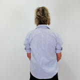 Person wearing a light blue striped shirt and black shorts against a white background