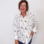 Woman wearing a white shirt with dog pattern against a white background