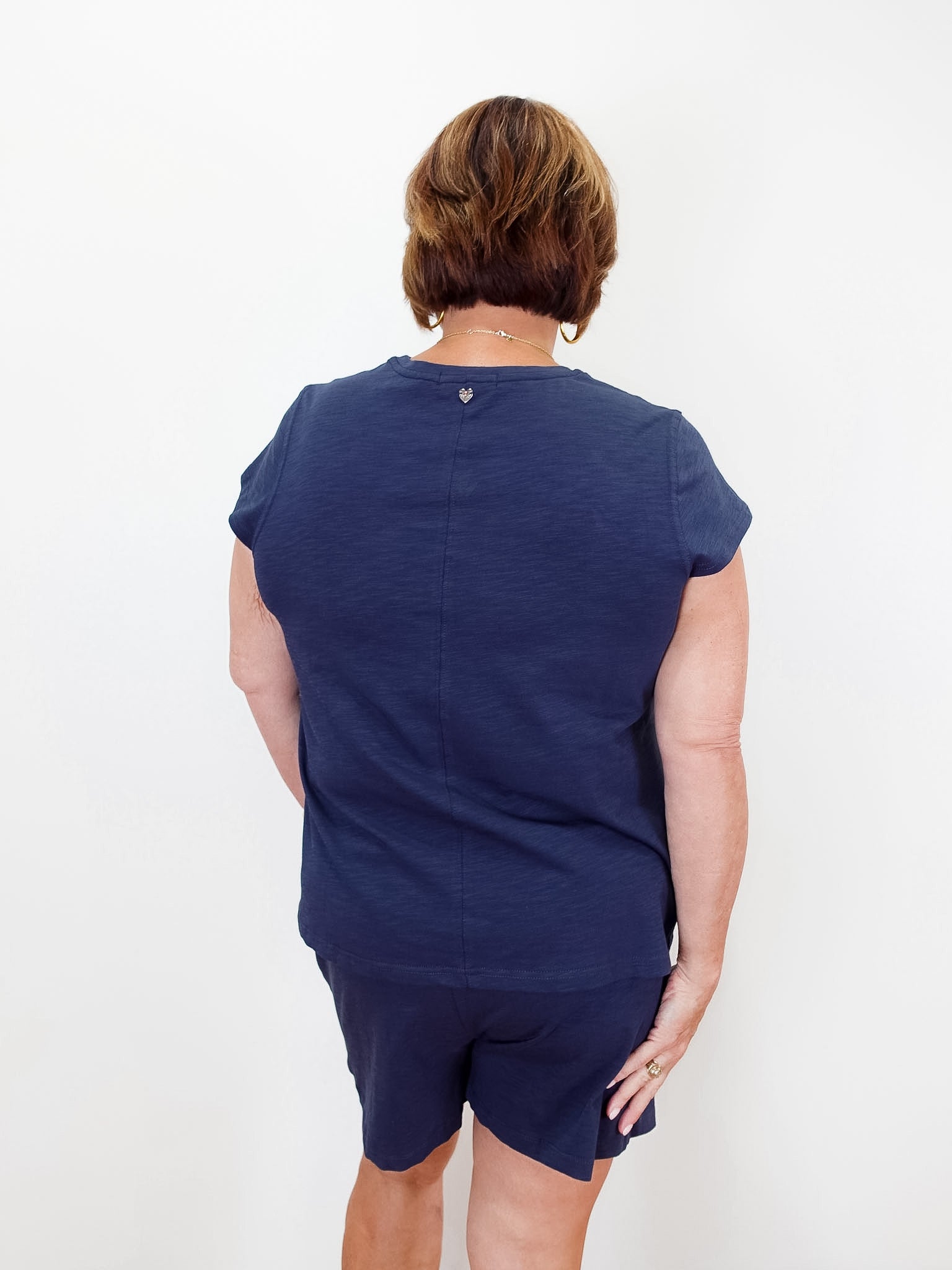 Person wearing a navy blue outfit on a white background