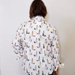 Person wearing a patterned shirt with dogs on a plain background