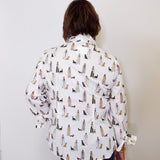Person wearing a patterned shirt with dogs on a plain background