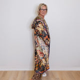 Person wearing a floral dress with leopard print accents against a white wall.