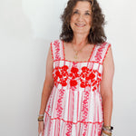 Woman wearing a red and white floral dress against a plain background
