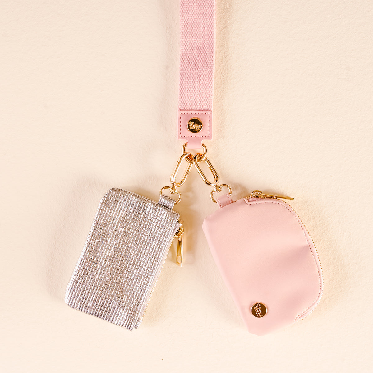 Pink and silver keychains on a beige background