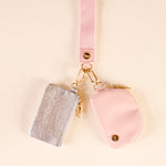 Pink and silver keychains on a beige background