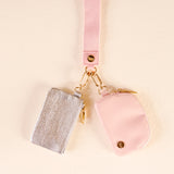 Pink and silver keychains on a beige background