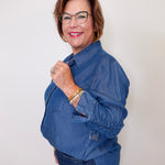 Woman wearing a blue Karen Kane denim shirt against a white background