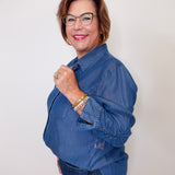Woman wearing a blue Karen Kane denim shirt against a white background