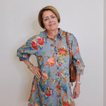 Woman wearing a floral dress with a plain background