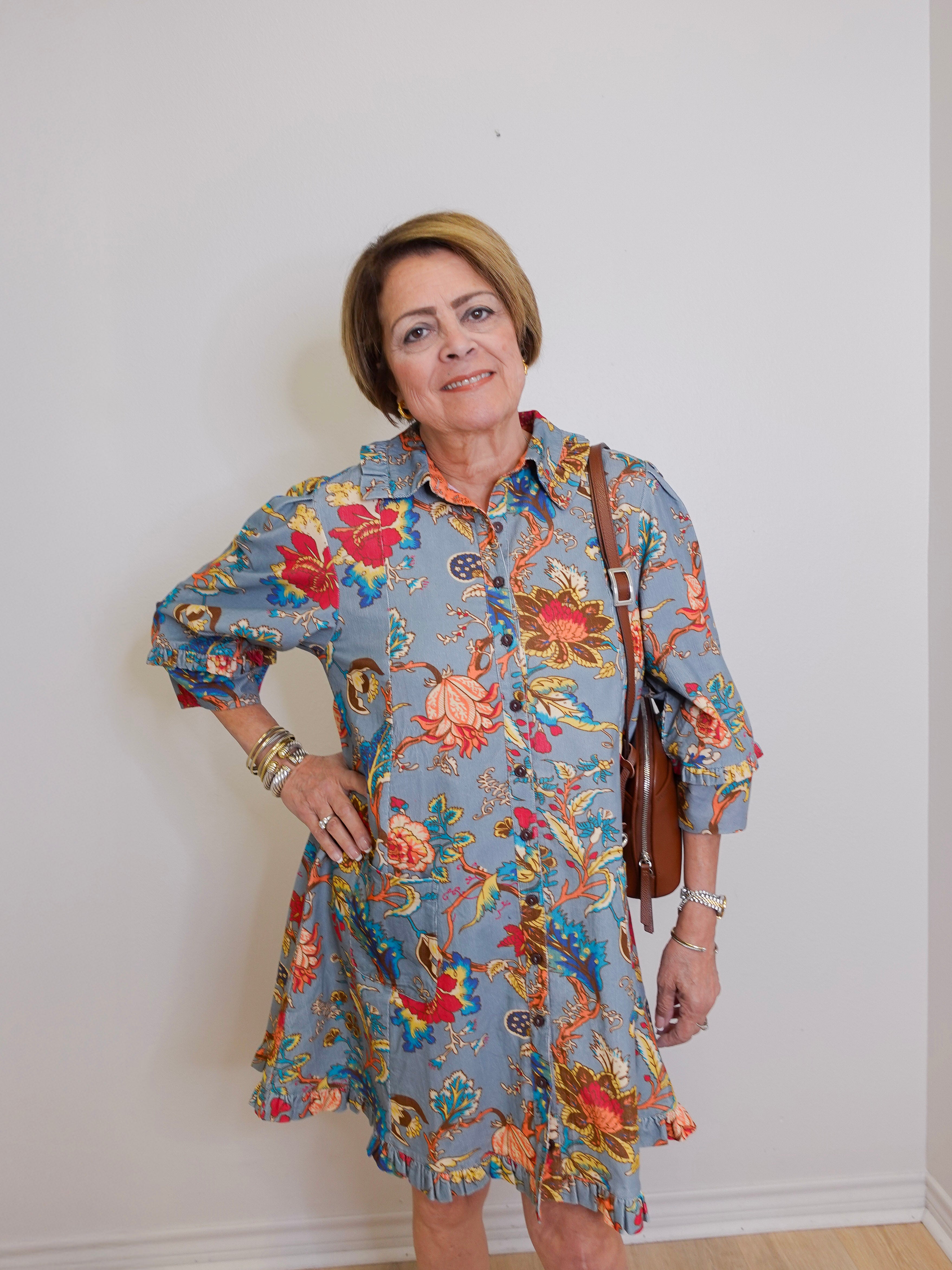 Woman wearing a floral dress with a plain background