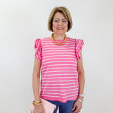 Woman wearing a pink and white striped shirt with ruffled sleeves against a plain background