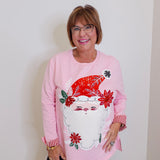 woman wearing a pink Santa baby long sleeve sweatshirt against a white background. 