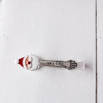 Spoon with Santa Claus design and 'Santa Stash' text on a white wooden surface