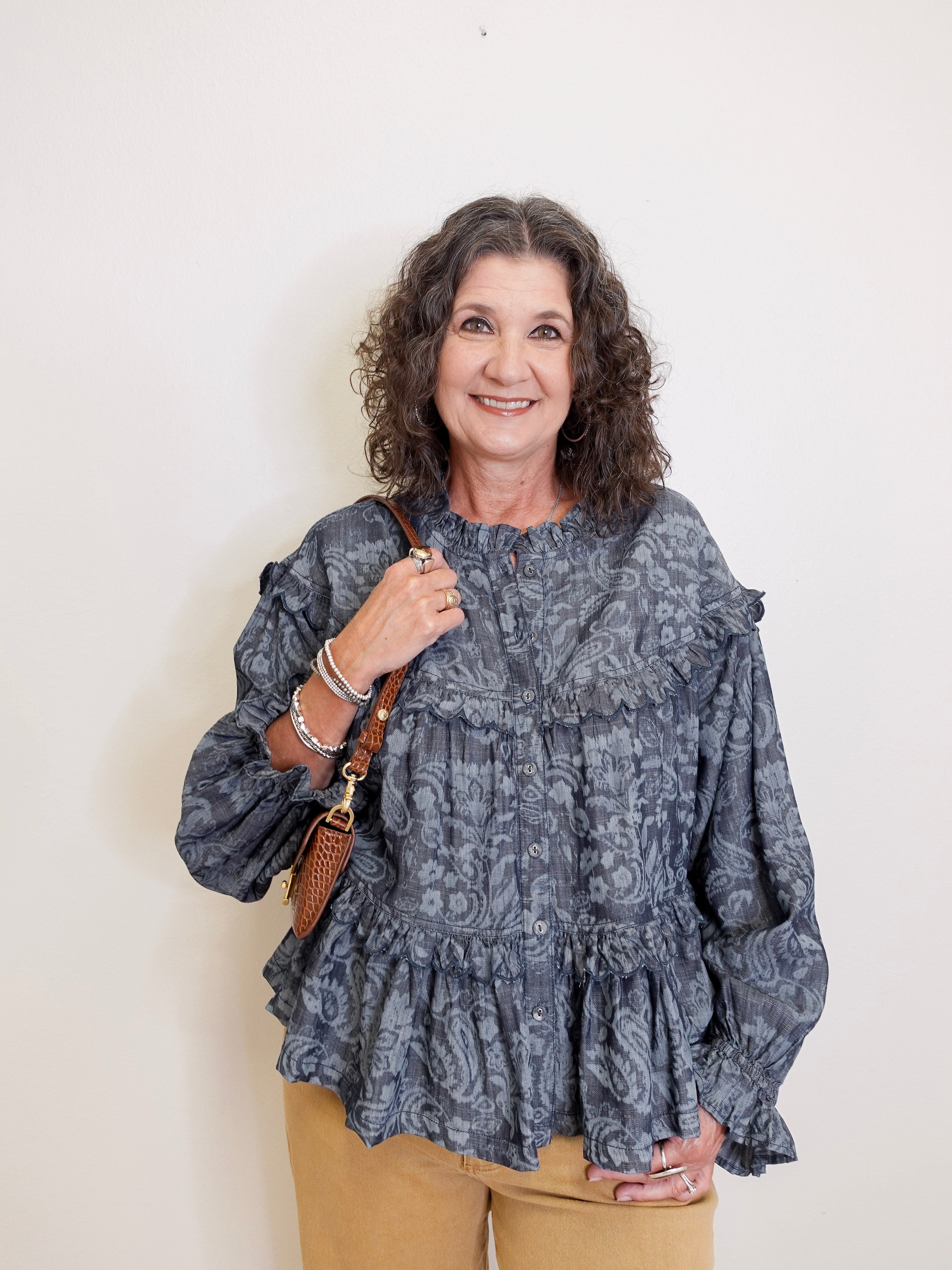 Woman wearing a patterned blouse with a plain background