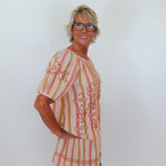 Woman wearing a patterned dress against a white background