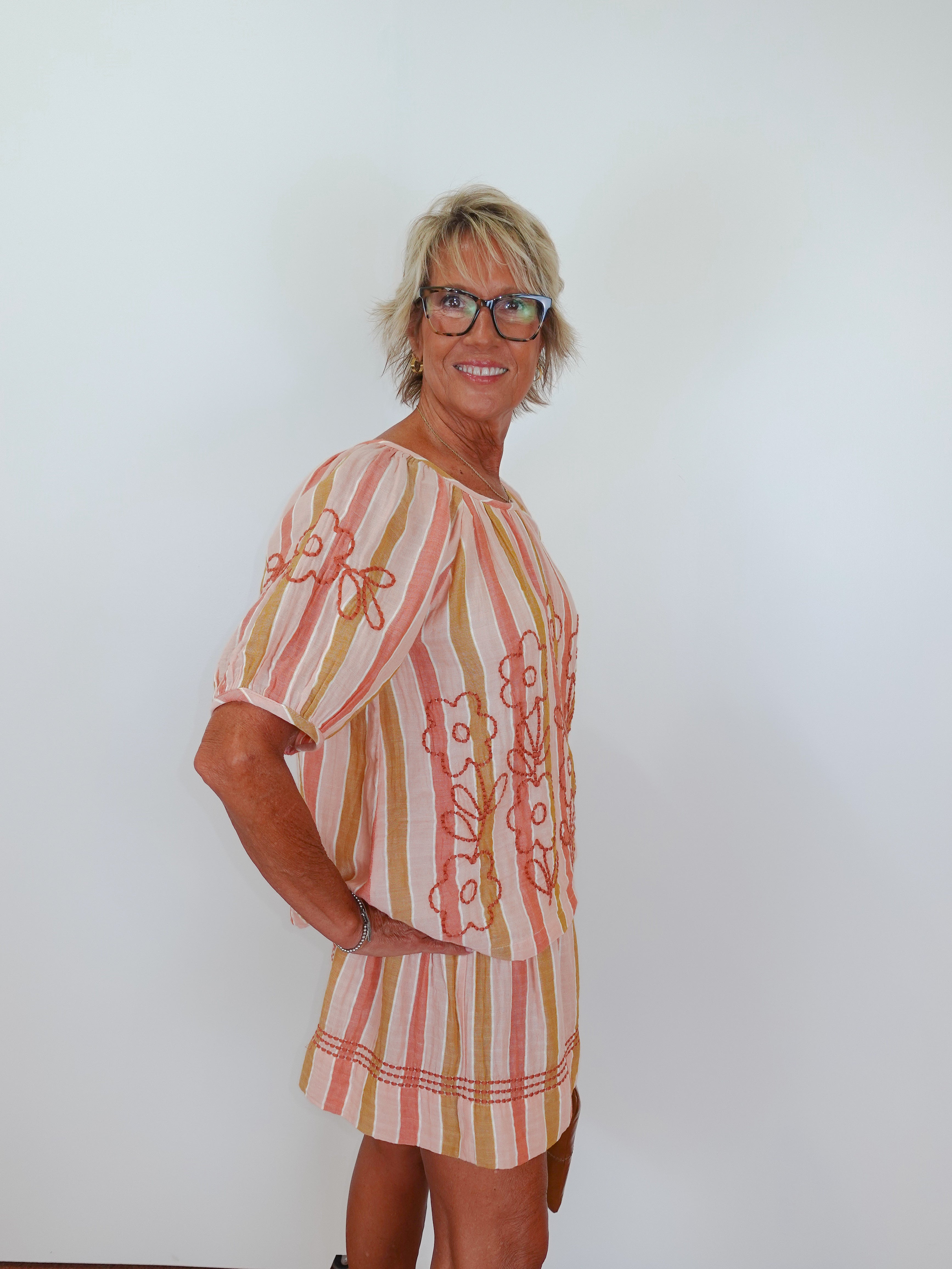 Woman wearing a patterned dress against a white background