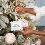 Person decorating a Christmas tree with a 'photo frame ornament' tag.