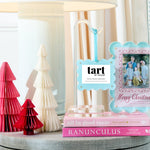 Decorative items including a lamp, books, and a photo frame with 'tart' branding on a table.