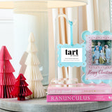 Decorative items including a lamp, books, and a photo frame with 'tart' branding on a table.