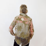Person wearing a floral patterned shirt against a white wall