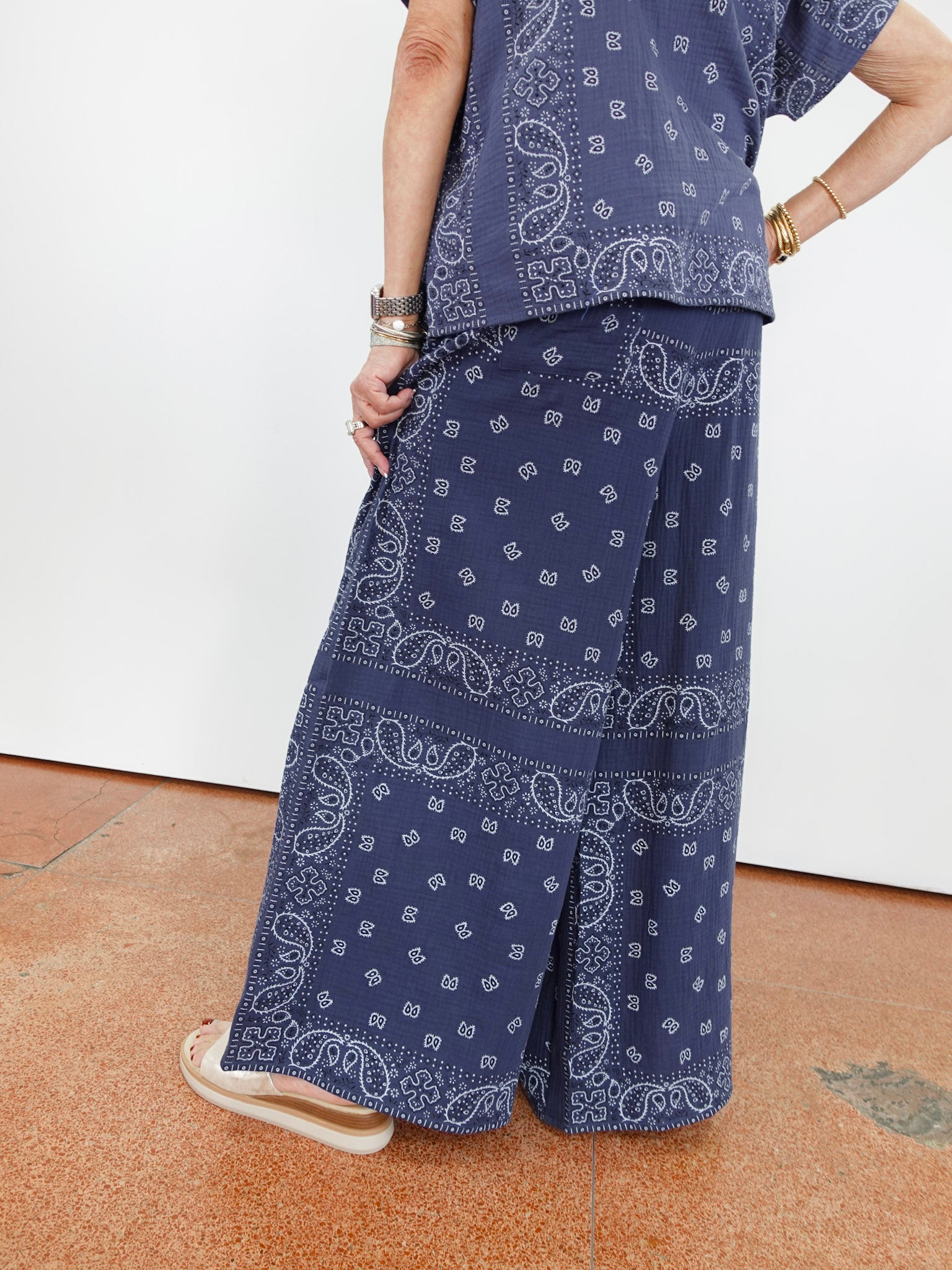 Person wearing a blue paisley patterned outfit on a white background
