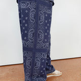 Person wearing blue paisley-patterned pants on a white background