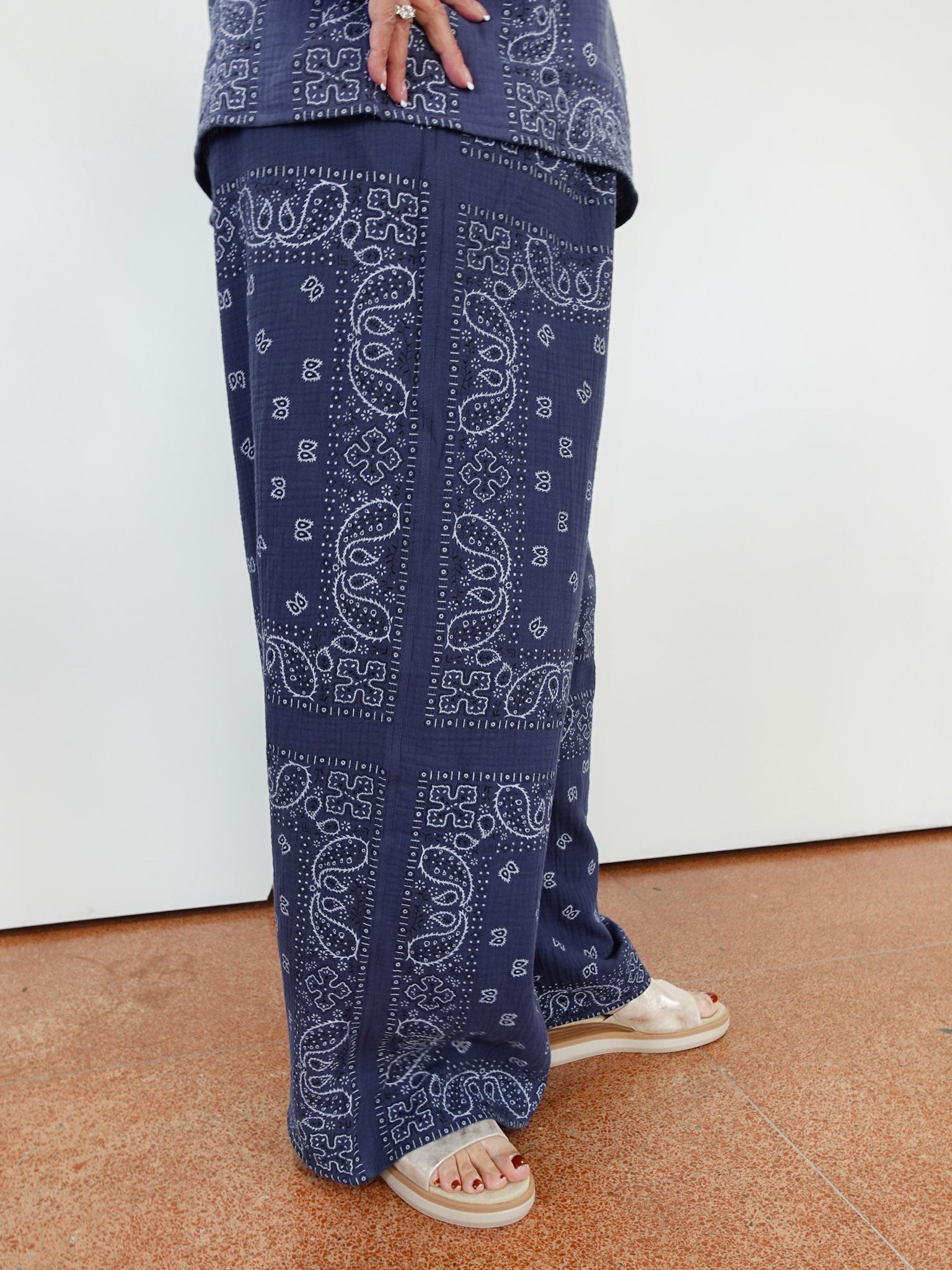 Person wearing blue paisley-patterned pants on a white background