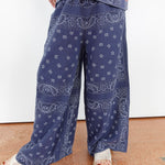 Person wearing blue paisley pants on a plain background