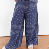 Person wearing blue paisley pants on a plain background