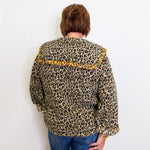 Person wearing a leopard print jacket with yellow accents on a white background