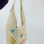 Woven handbag with tropical designs on a white background